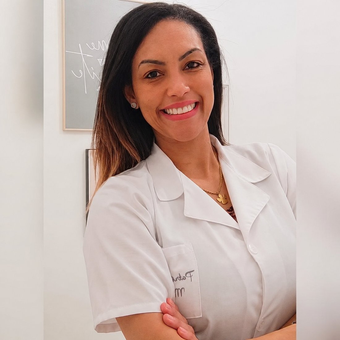 Patricia Medeiros, terapeuta de massagem, sorridente e de bata branca